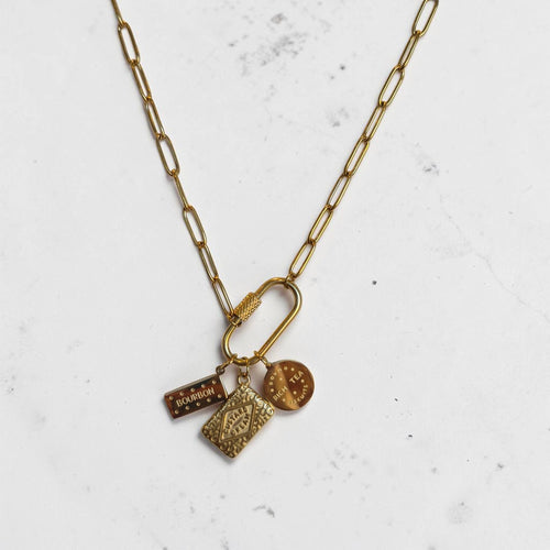 Gold necklace with charms on a light gray background